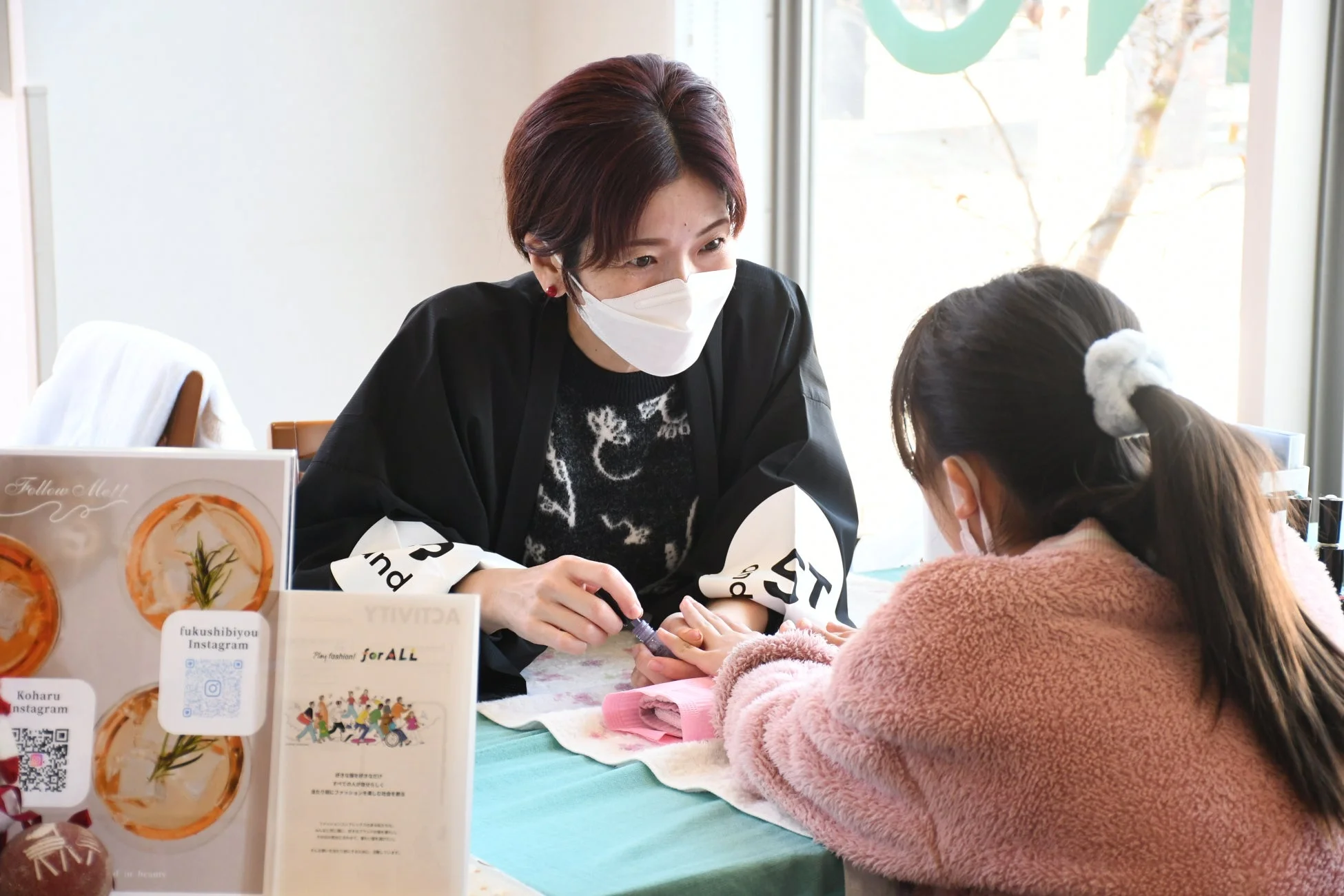 子供にネイルケアを施す女性