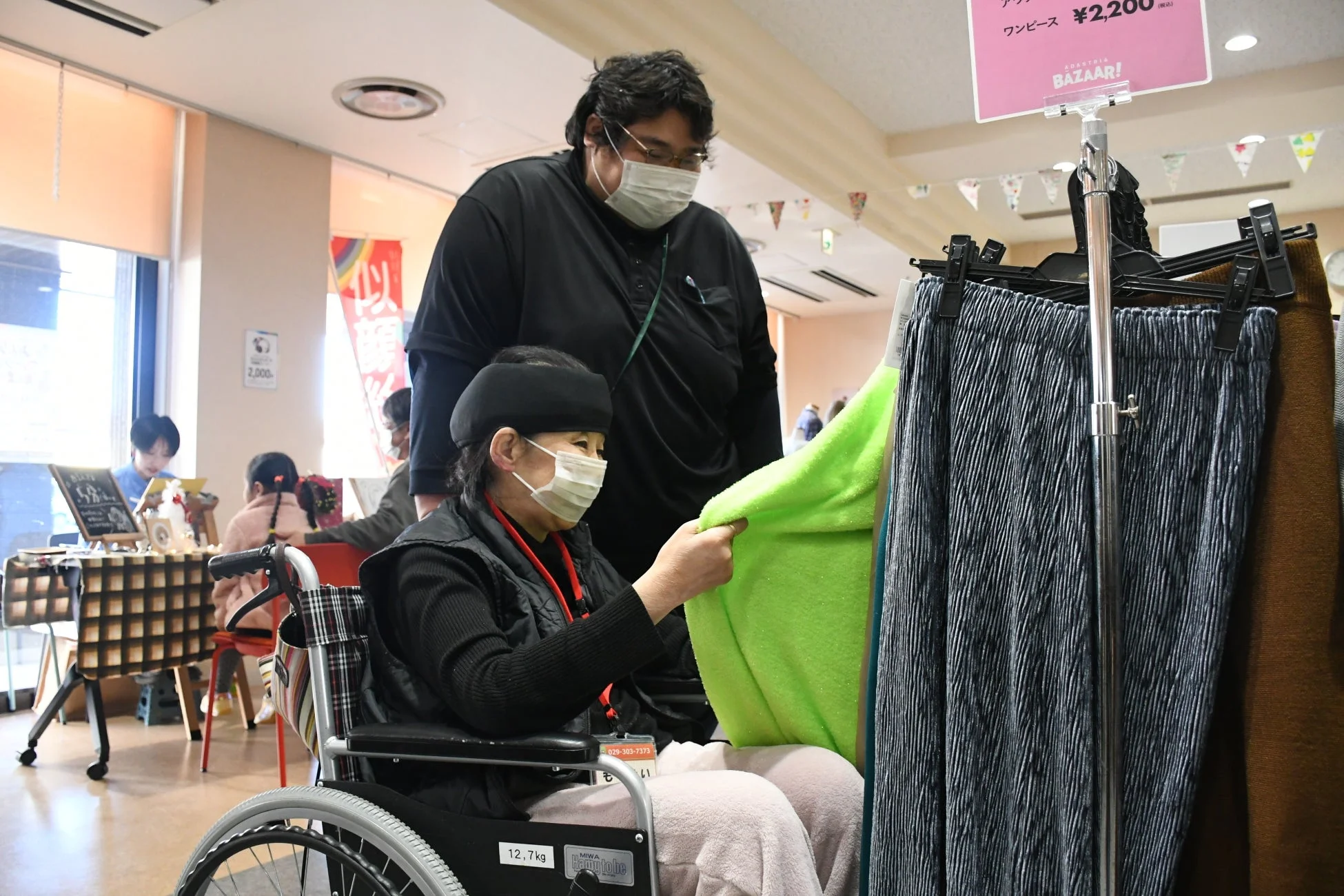 バザールで服を選ぶ車椅子の女性