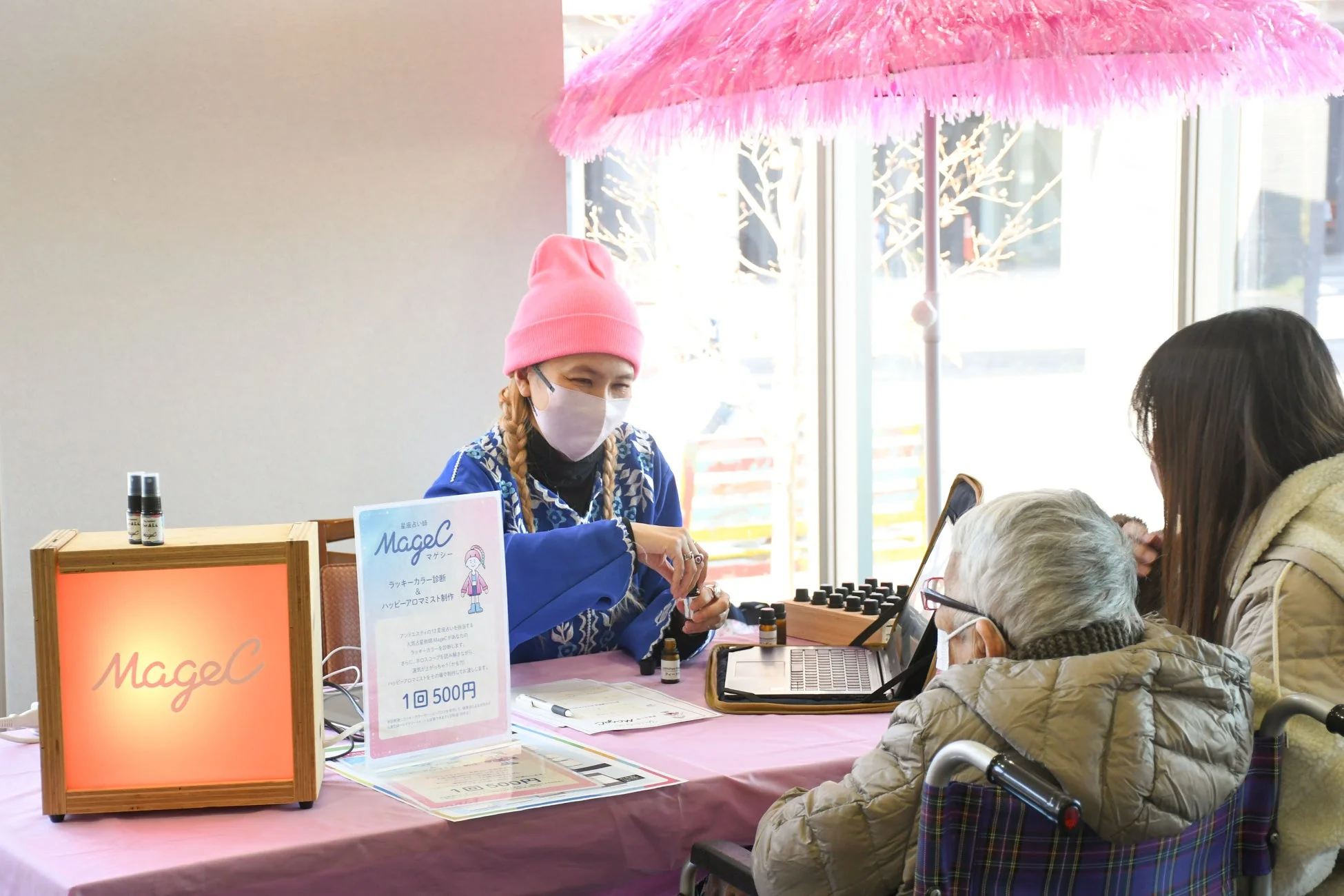 アロマ製品の説明をする女性と車椅子の高齢者