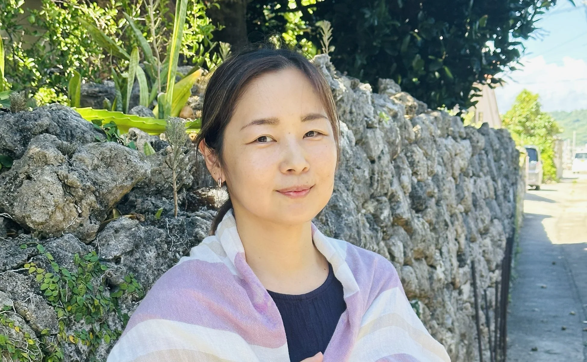 石垣の前で微笑むNPO法人ダイバーシティ工房 代表 不破牧子氏