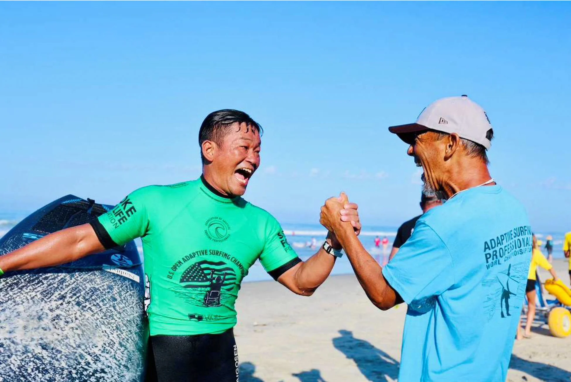 アダプティブサーフィン大会で笑顔で握手する2人の男性
