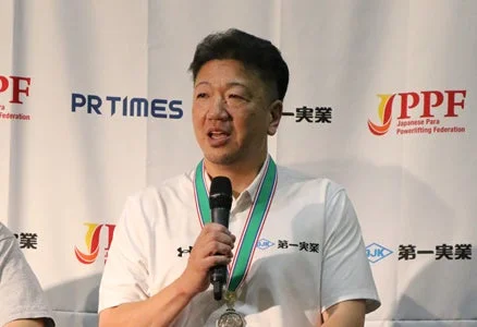 石原正治選手がマイクを持ってスピーチしている様子