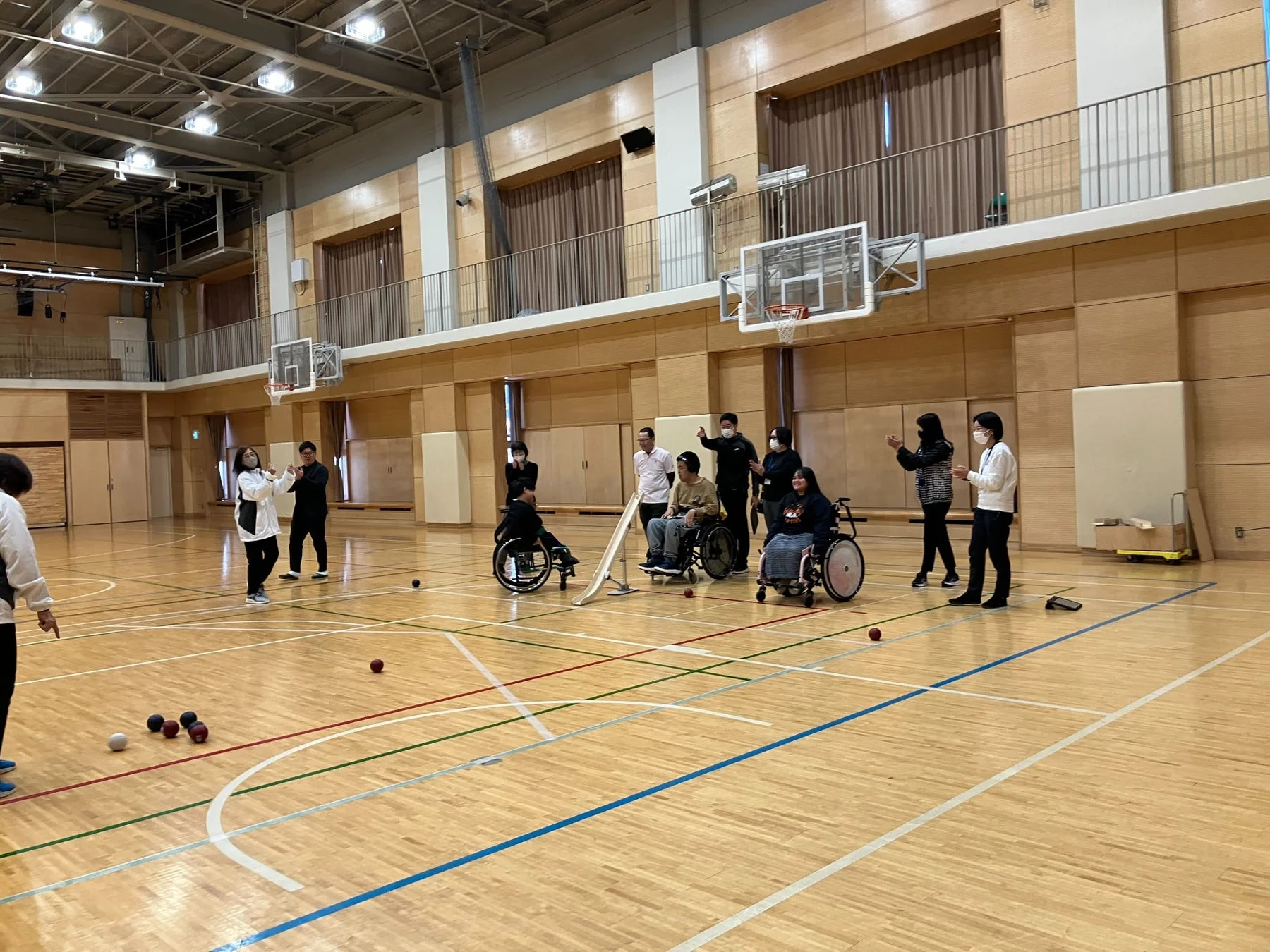 体育館でボッチャを楽しむ人々の様子を捉えた画像