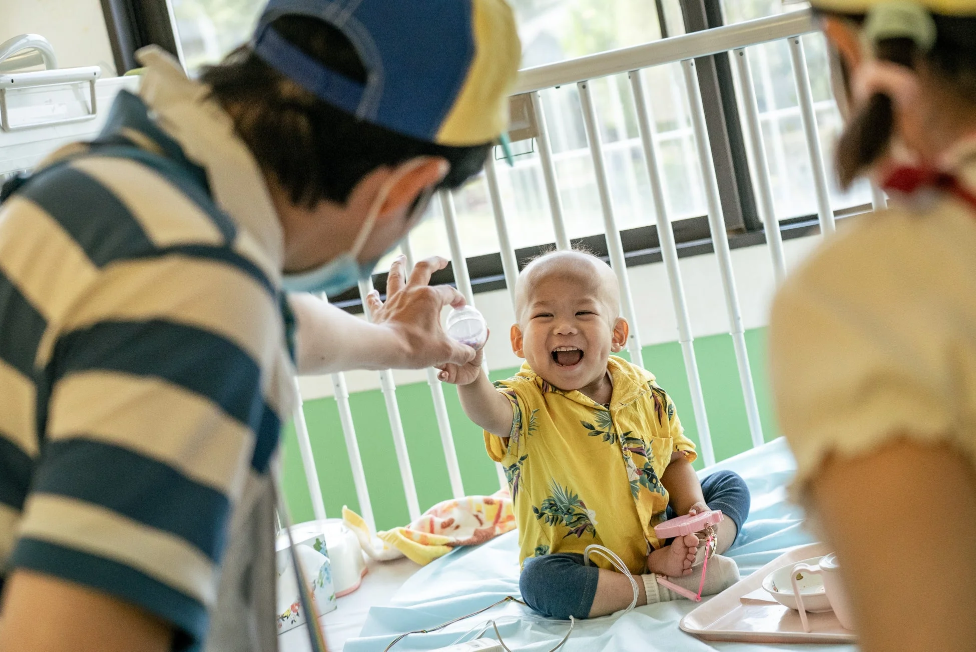病院のベビーベッドで笑顔の赤ちゃん