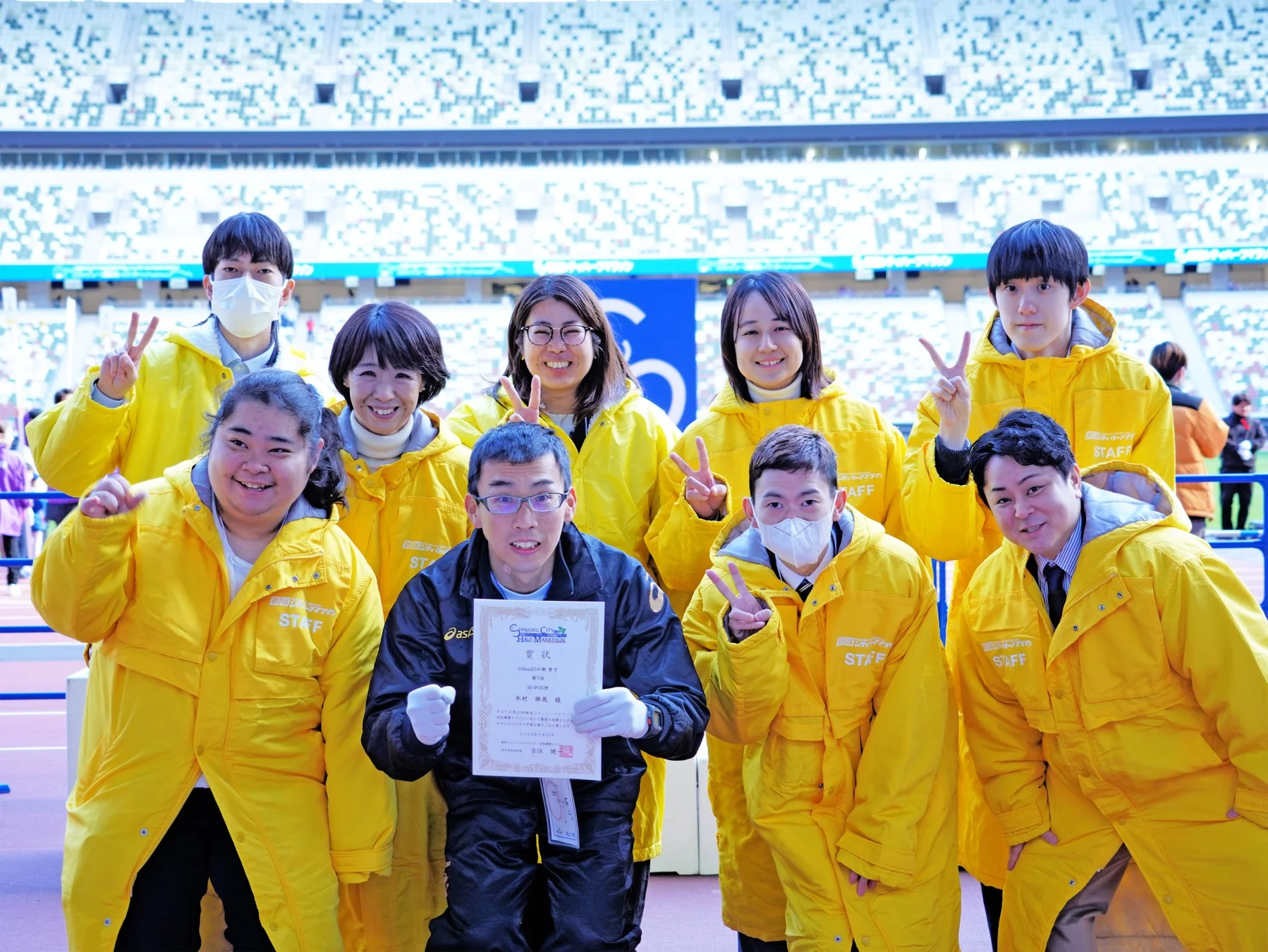 新宿シティハーフマラソンと思われるイベントで、スタッフが集合写真を撮っている様子