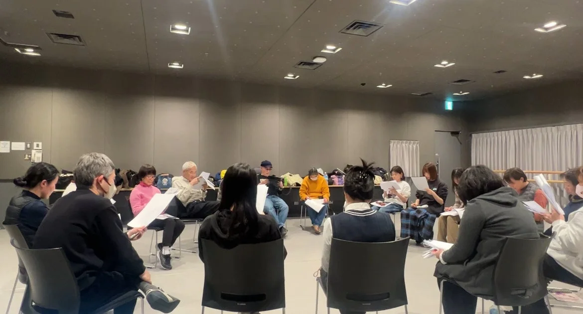 円形に座り資料を読む人々