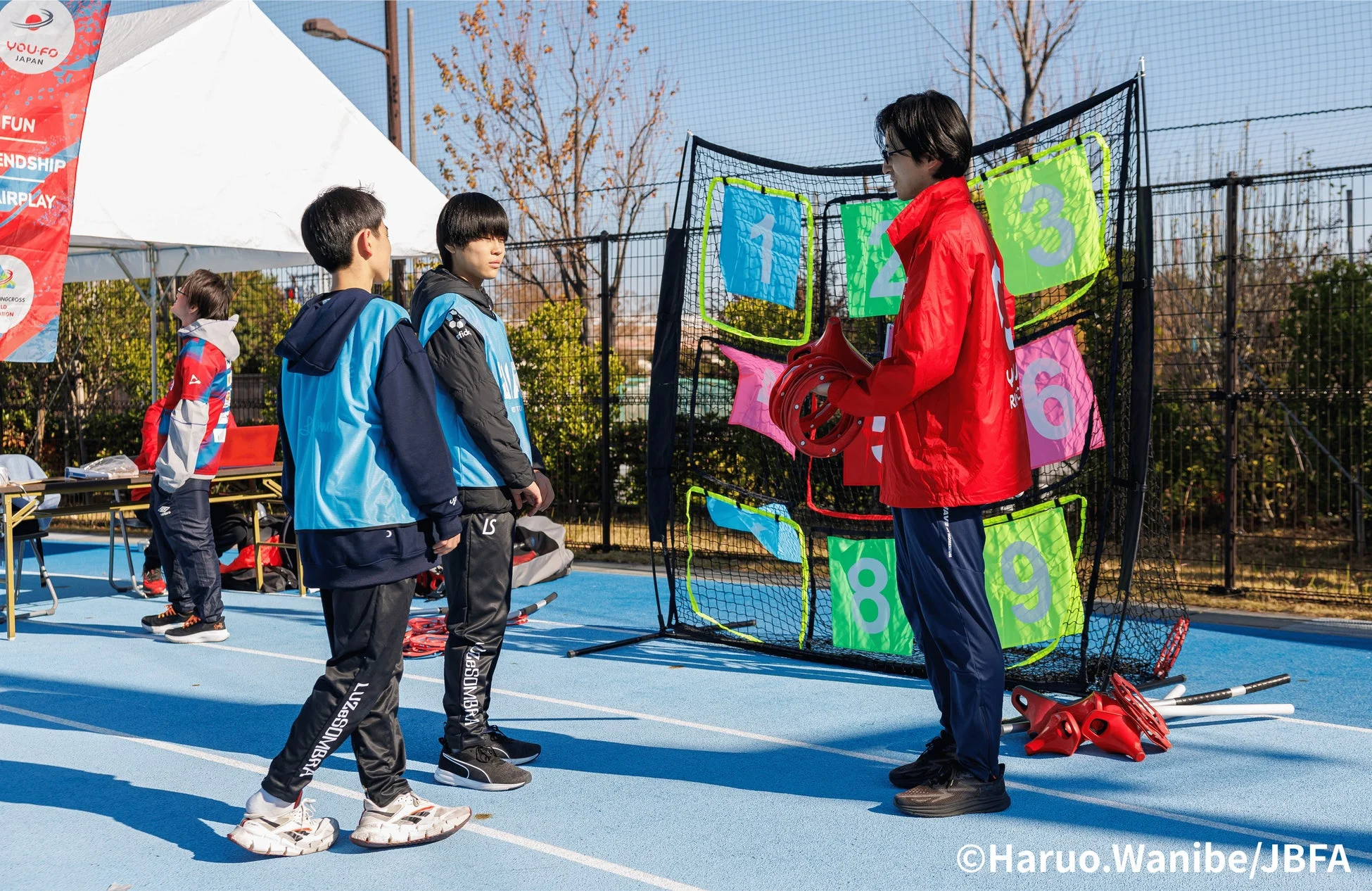 指導者が子供たちにYOU.FOのターゲット練習を教えている様子