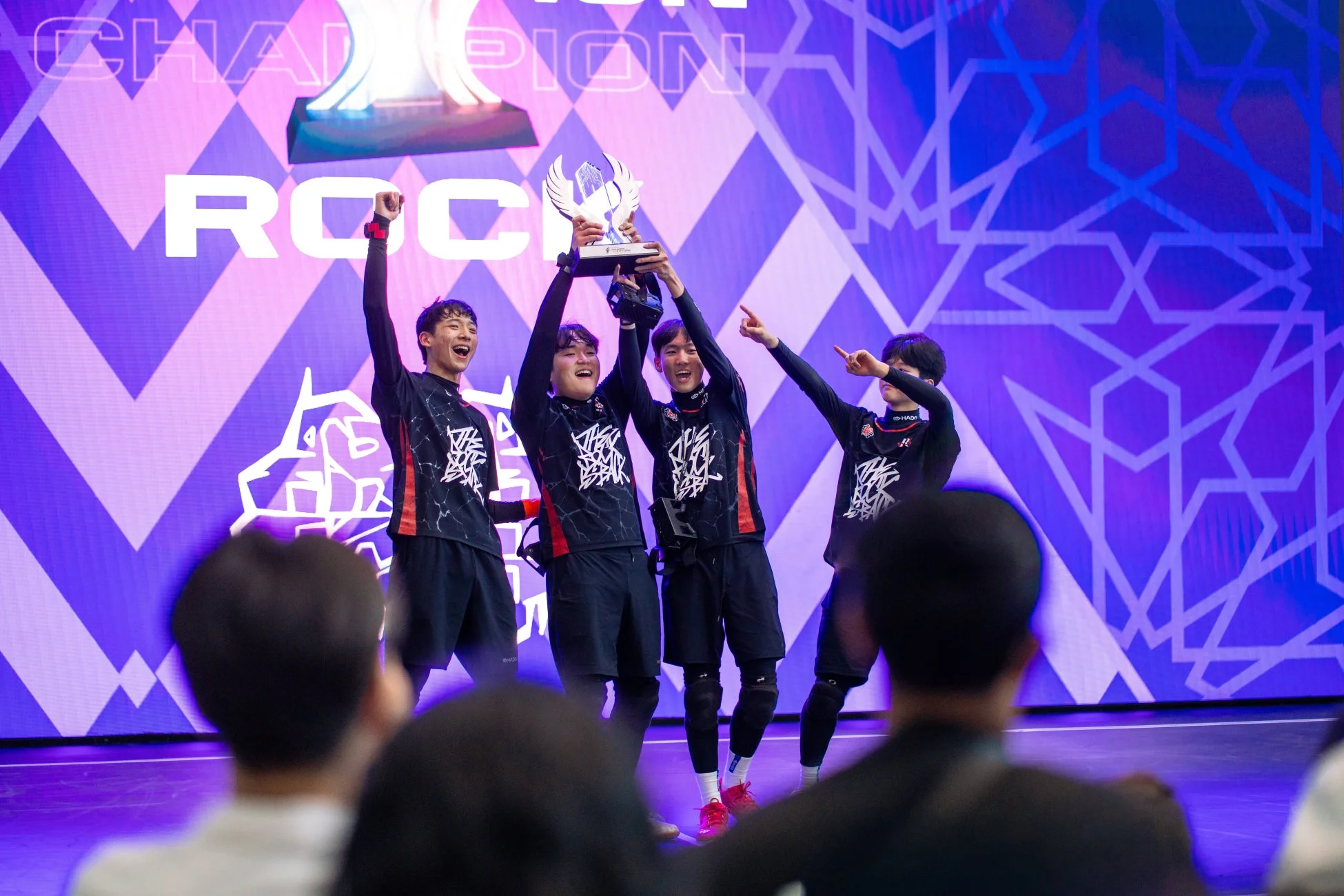 eスポーツの大会で優勝し、トロフィーを掲げて歓喜する4人組のチーム