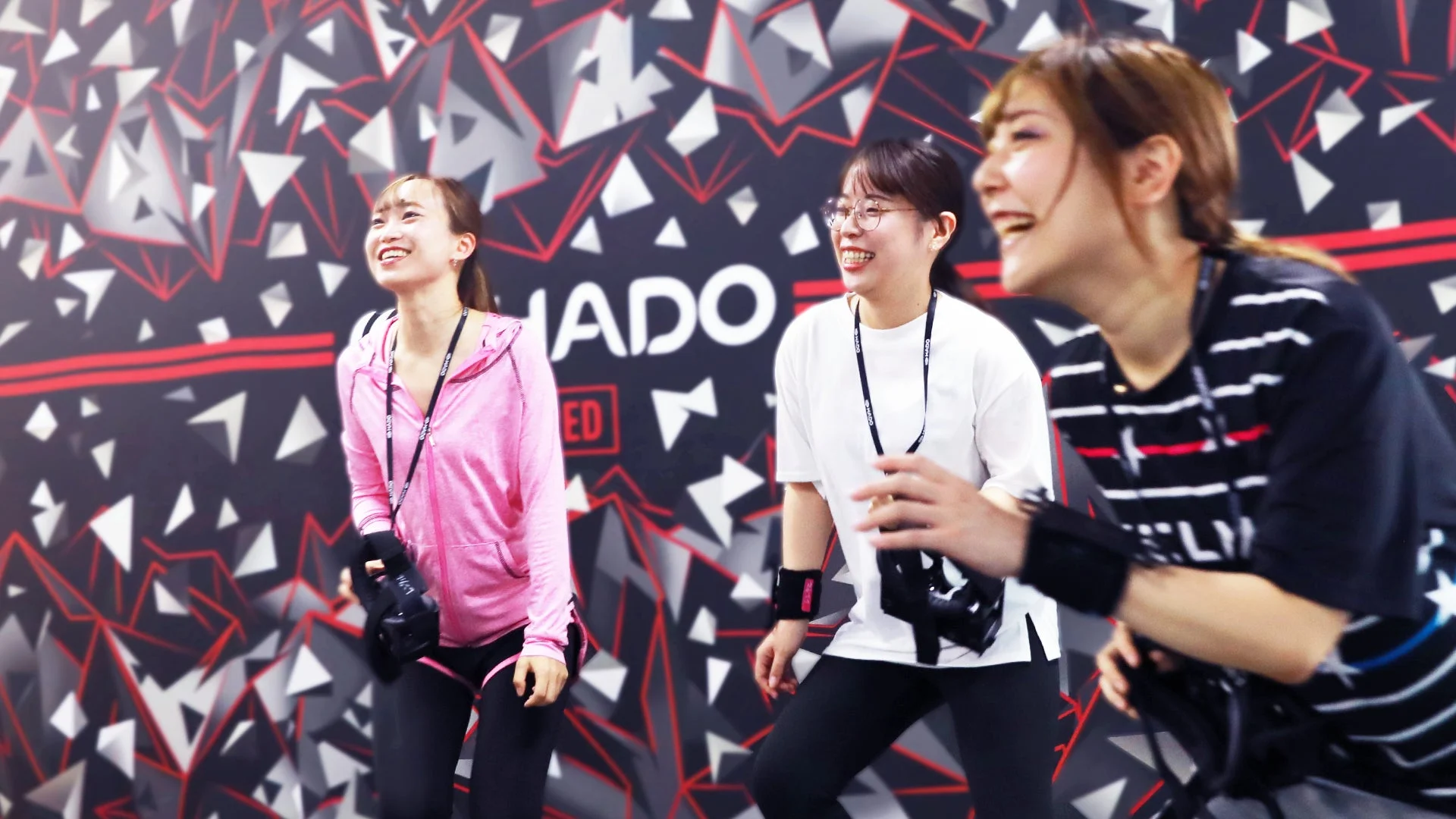 3人の若い女性がHADOのようなAR/VRアクティビティを体験し、笑顔で楽しんでいる様子です。