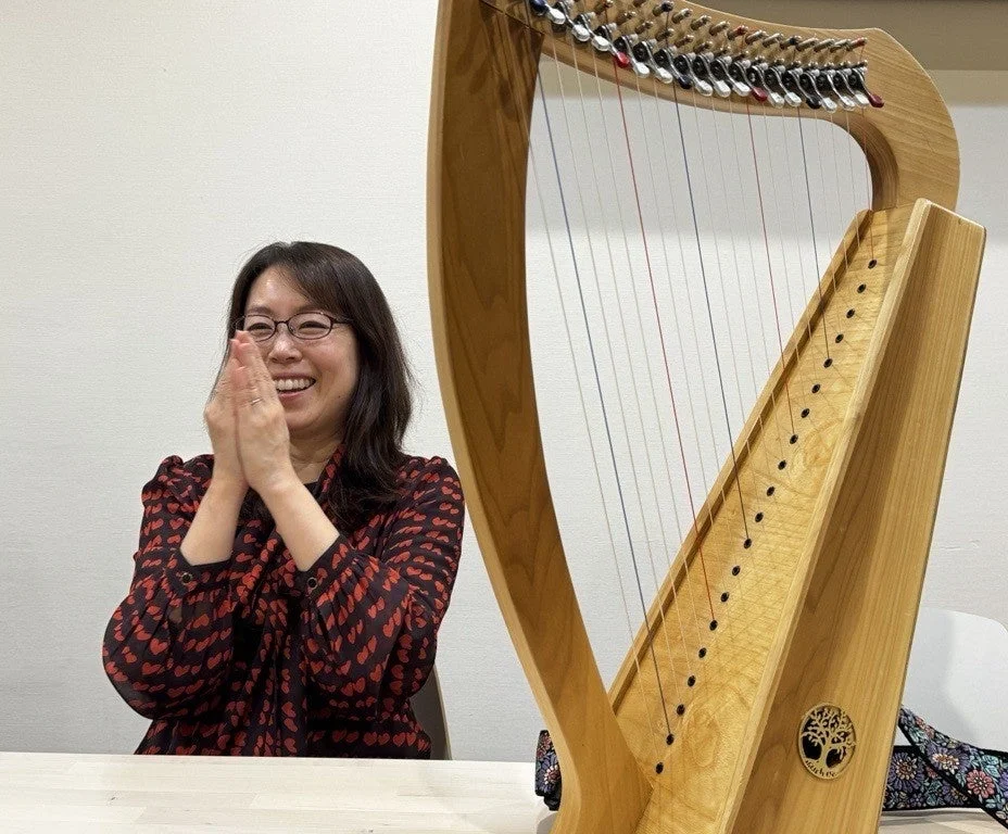 笑顔でハープを演奏する曽我あかね氏