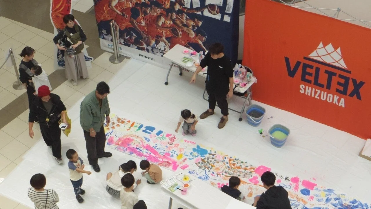 子供たちが絵の具で共同制作している様子