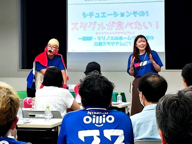 セミナーで話す女性とマスコット