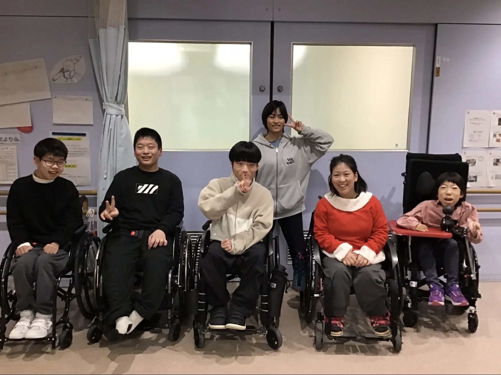 車椅子に乗った若者と子供たちのグループ