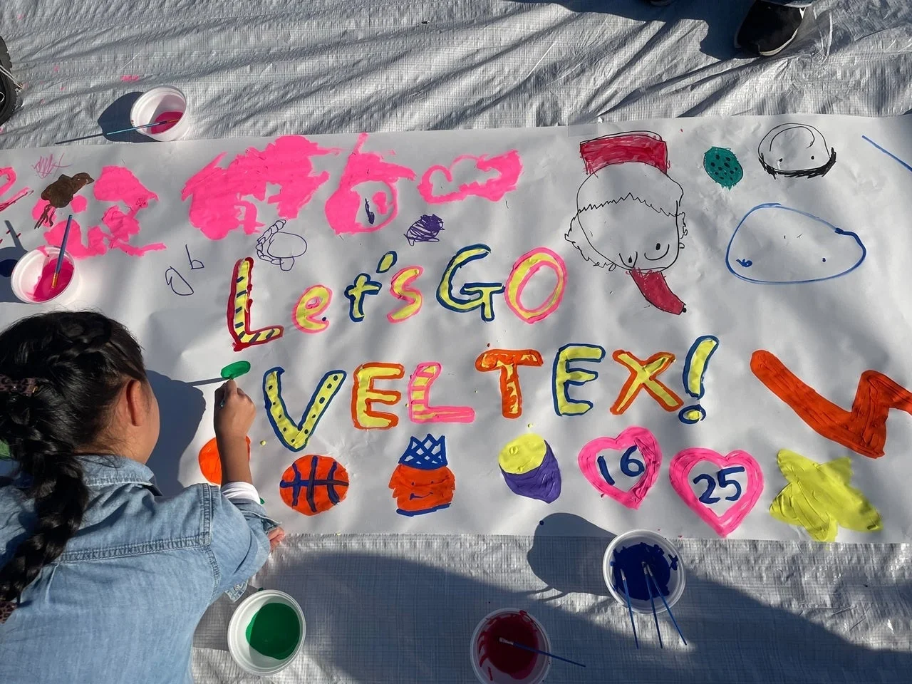 子供が屋外でバナーに描いている様子