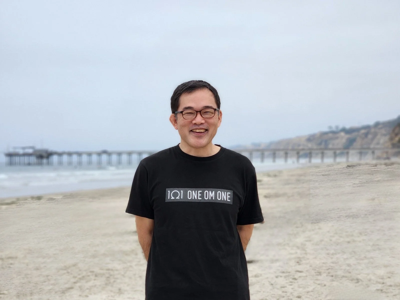 男性、ビーチ、桟橋、海、笑顔、眼鏡、黒Tシャツ、屋外、曇り空