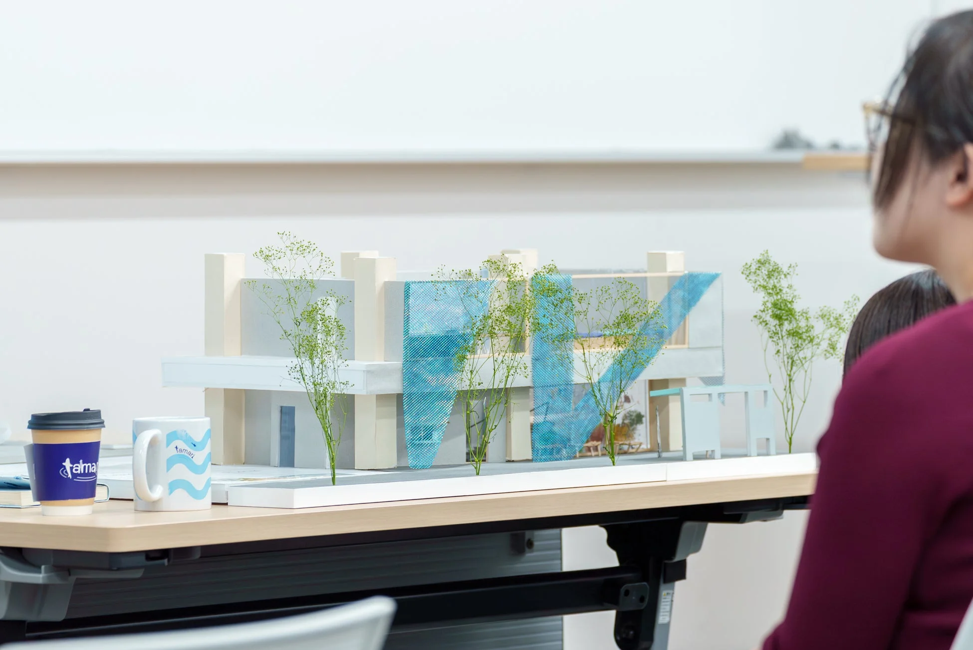 建築模型を囲む人々