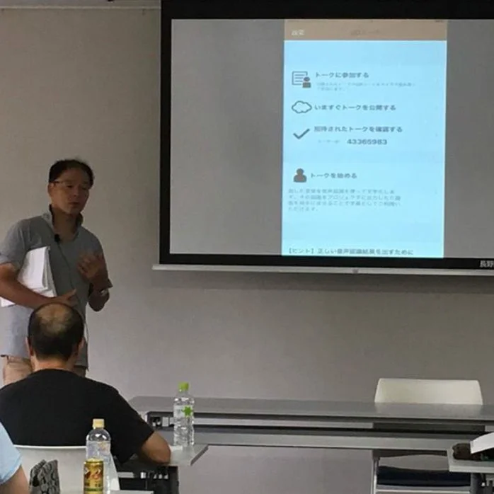 会議室でプレゼンテーションを行う男性