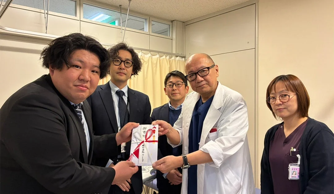 白衣の男性への祝儀袋贈呈