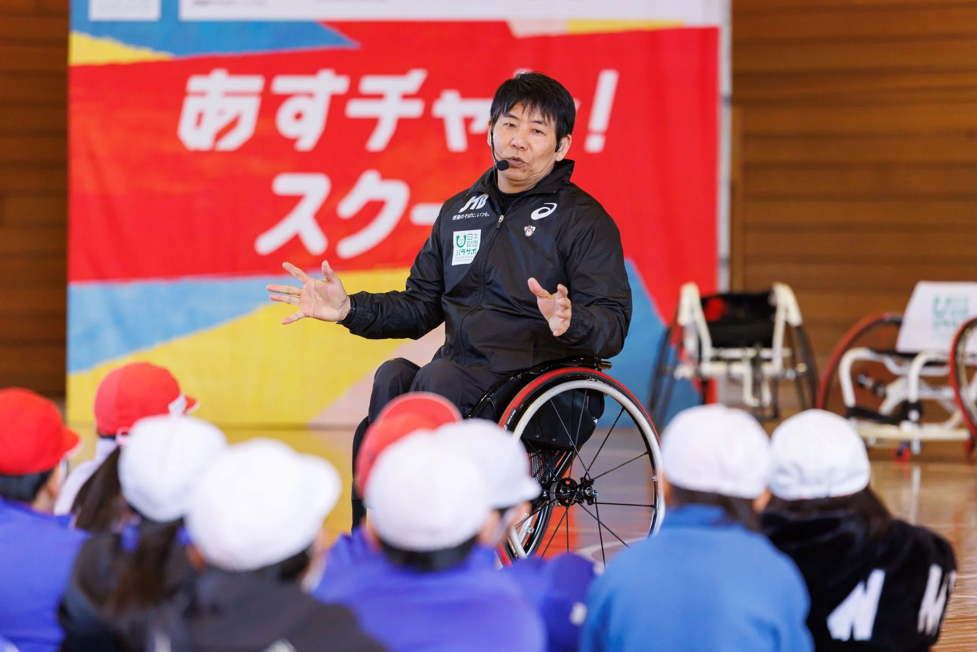 車いすの講師が子どもたちに語りかける様子