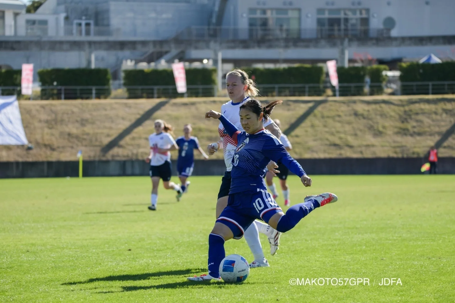 サッカー試合中にボールを蹴る選手