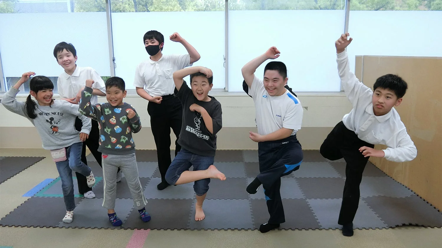 子供たちが笑顔でポーズを取る室内活動の様子