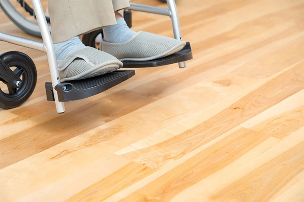 車椅子に乗った人の足元と介護用スリッパ