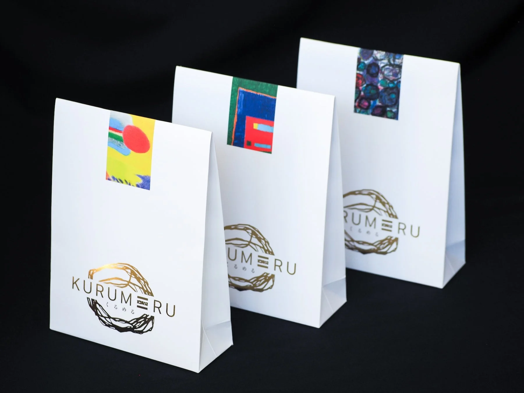 黒い背景に白地の紙袋が3つ並んでいます。