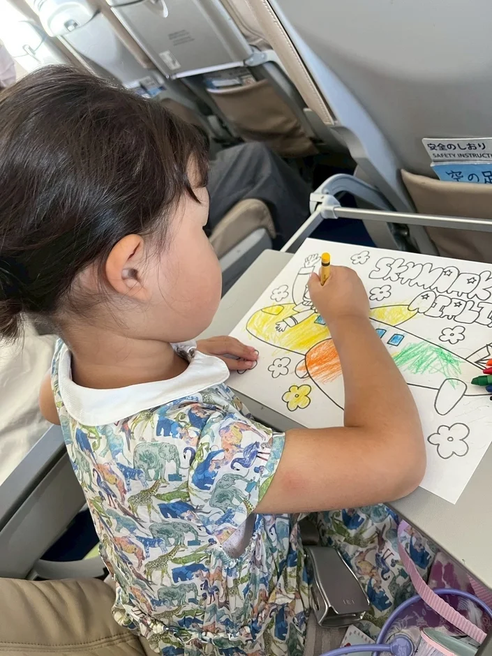 飛行機で塗り絵をする子供