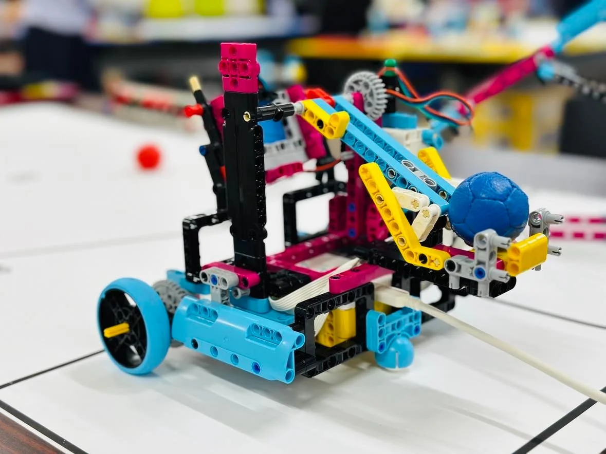 カラフルなブロックで組み立てられたロボットが青いボールを保持