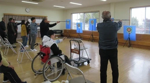 吹き矢をする人々