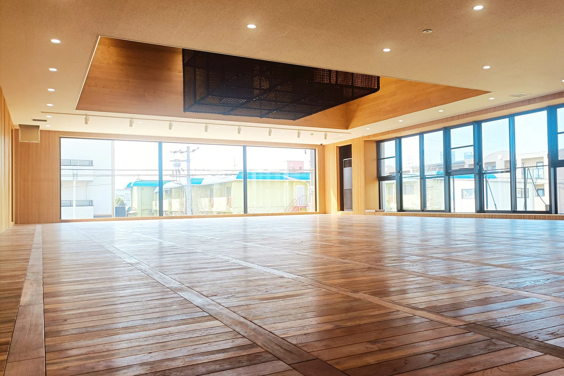 広々とした明るい空間で、美しい木目のフローリングが特徴的です。大きな窓からは自然光がたっぷりと差し込み、開放感があります。モダンな内装デザインで、多目的な利用が可能な清潔感のある部屋です。