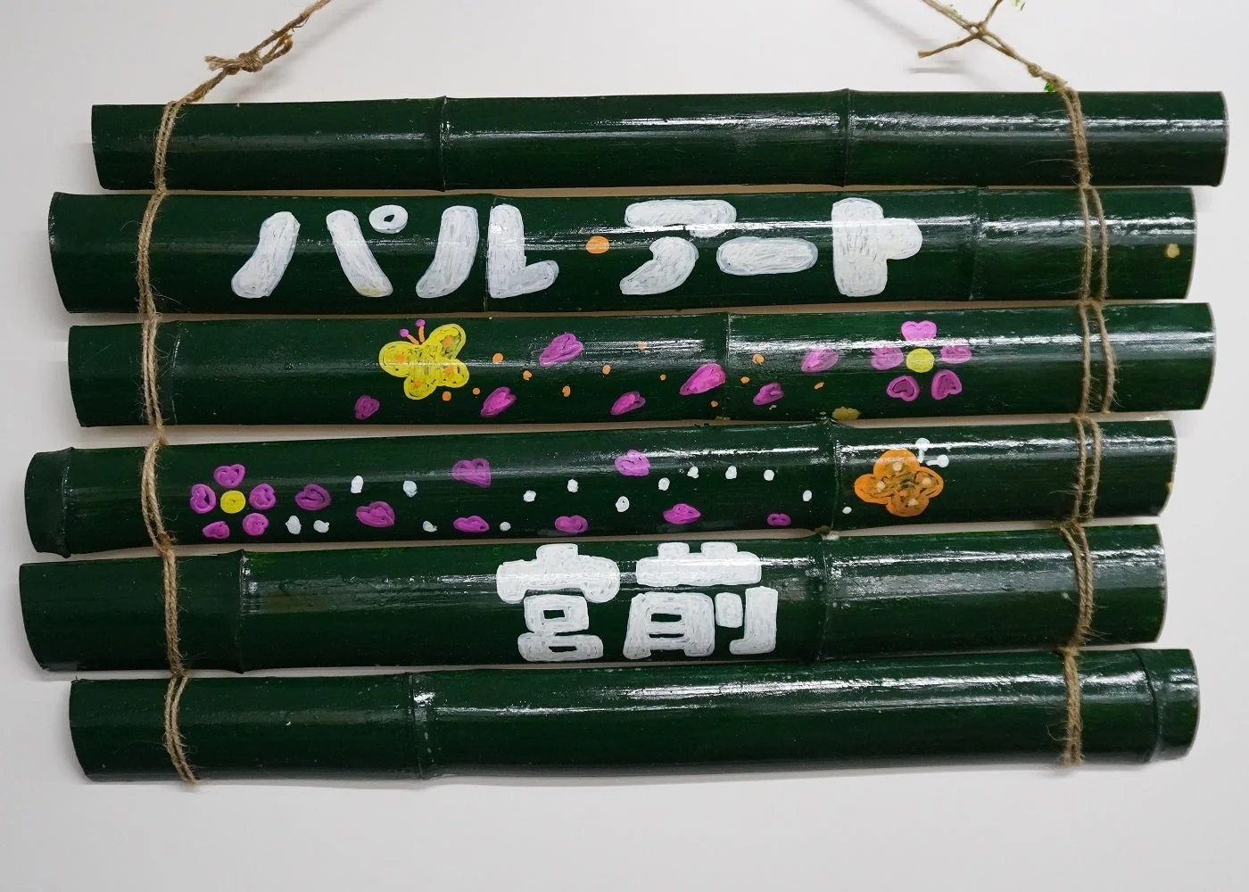 緑色の竹を数本束ねて作られた壁飾りです