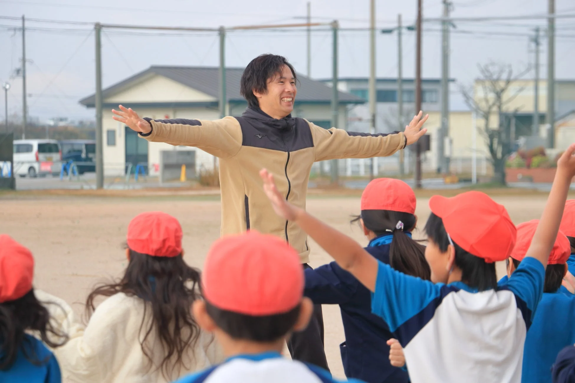 屋外で体操する子どもたちと指導者