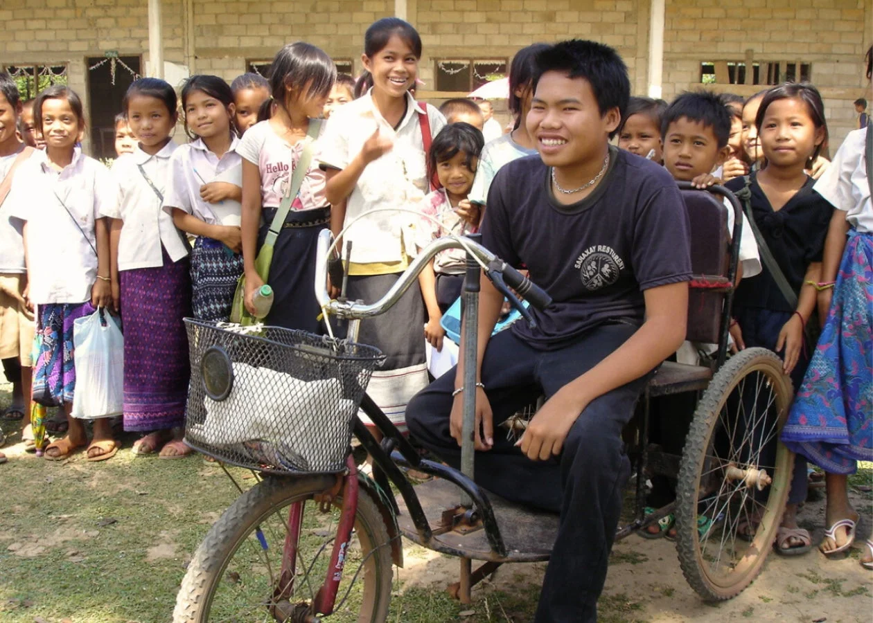 屋外で多くのアジア系の子どもたちが笑顔で集まっています