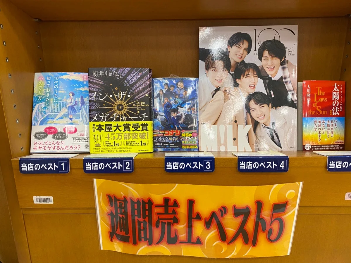 書店内の書籍陳列棚。週刊売上ベスト5の告知があり、個別の書籍には「当店のベスト」として1位から4位までが紹介されている。