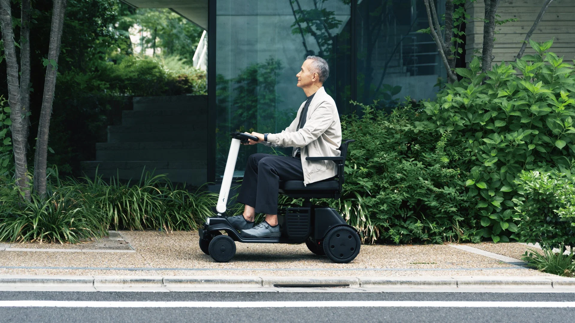 電動モビリティスクーターに乗って移動する高齢の男性