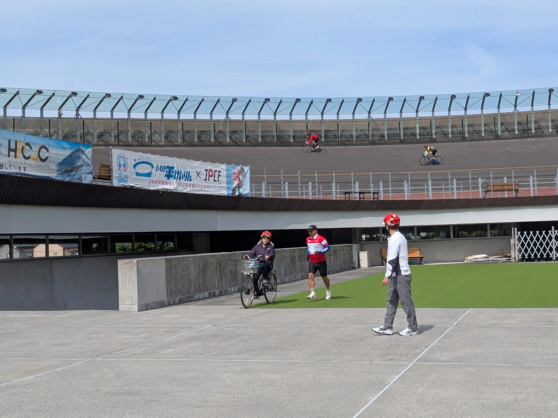 晴れた日に競輪場で行われている自転車競技または練習風景