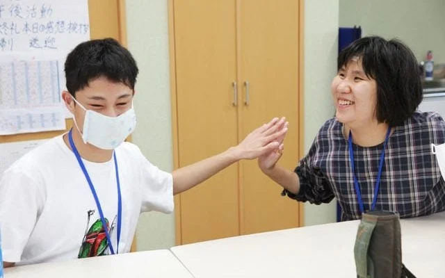 笑顔でハイタッチをする人々