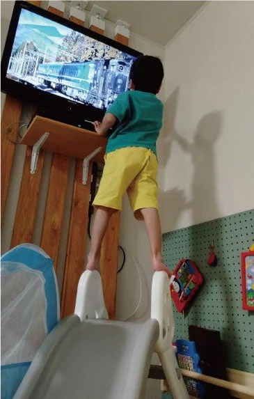 滑り台を使ってテレビを見る子ども