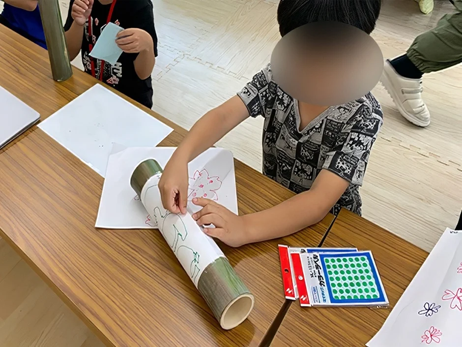 子供たちがテーブルで工作活動をする様子