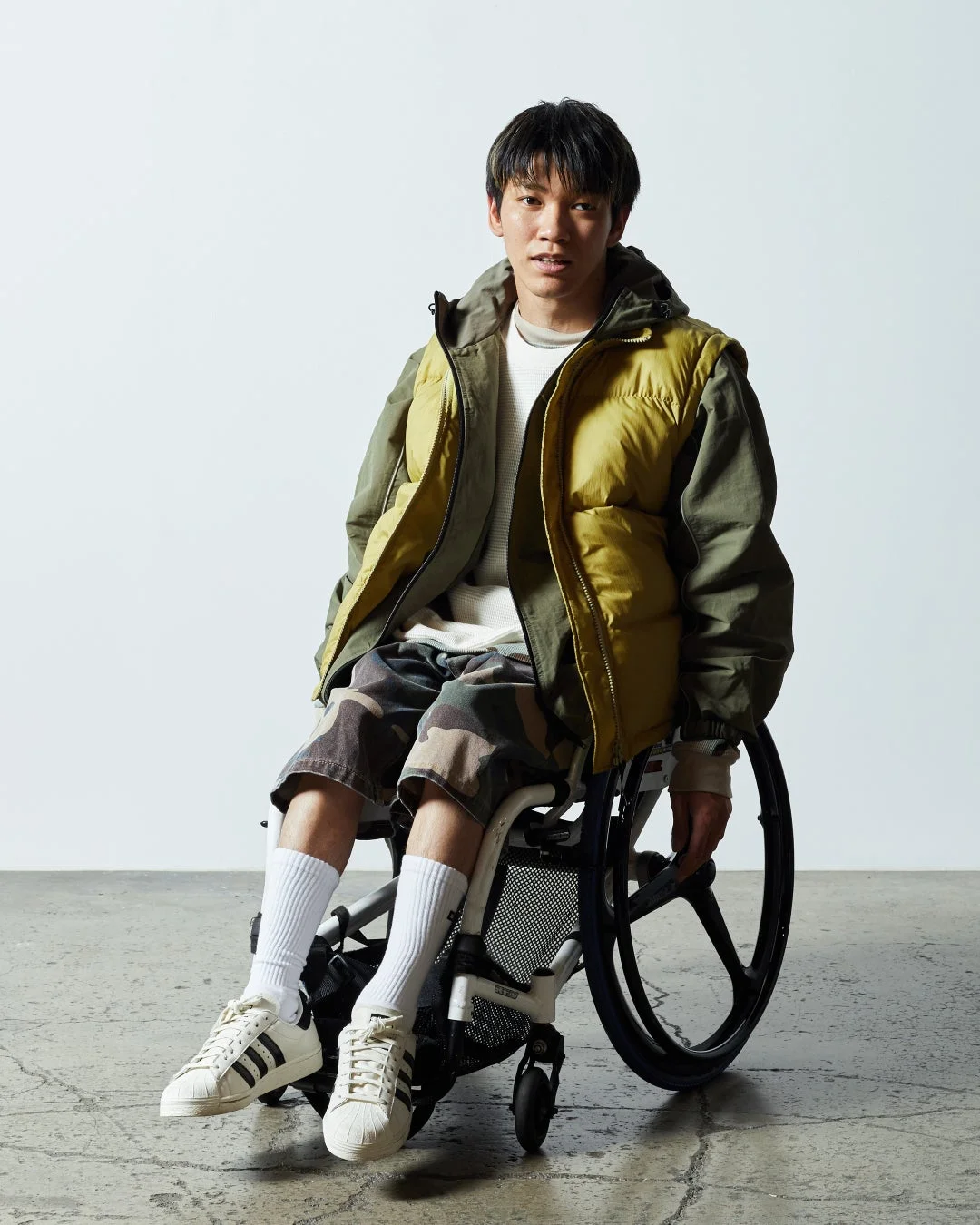 車椅子に座った若い男性がカメラを見つめているポートレート