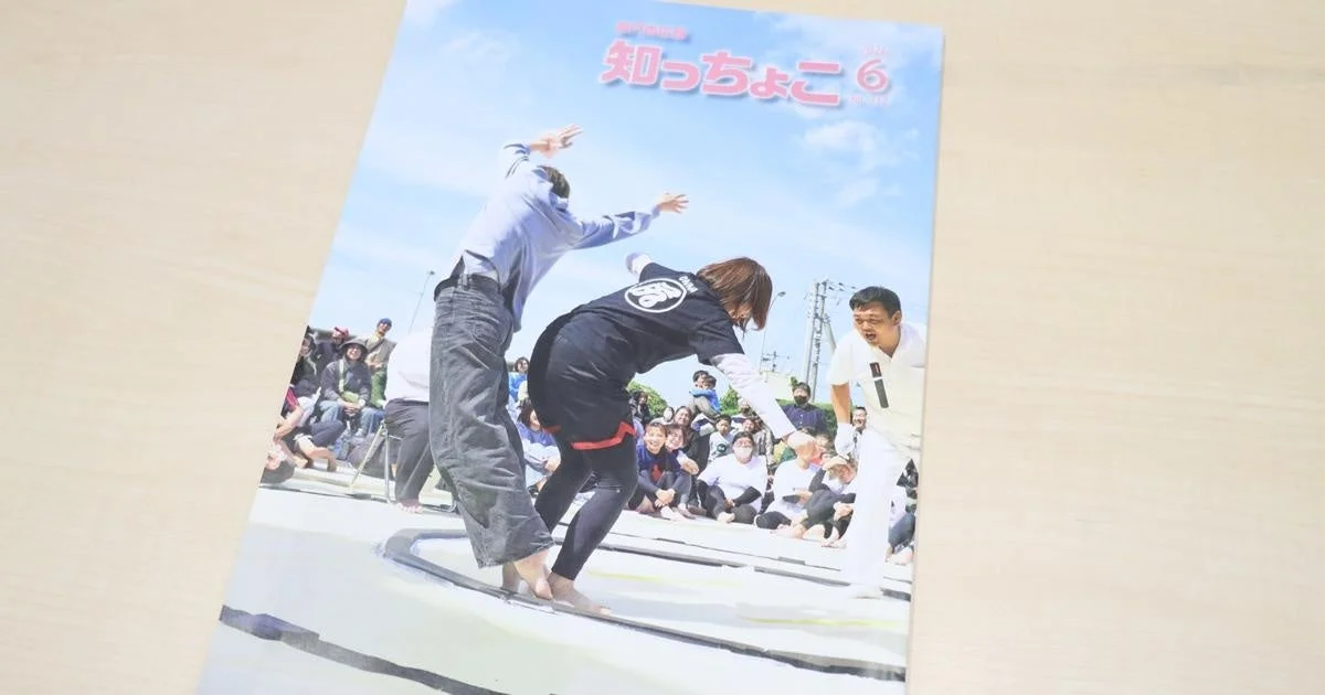 屋外のイベント会場で、人々が細いラインの上でバランスを取るゲームに参加している様子