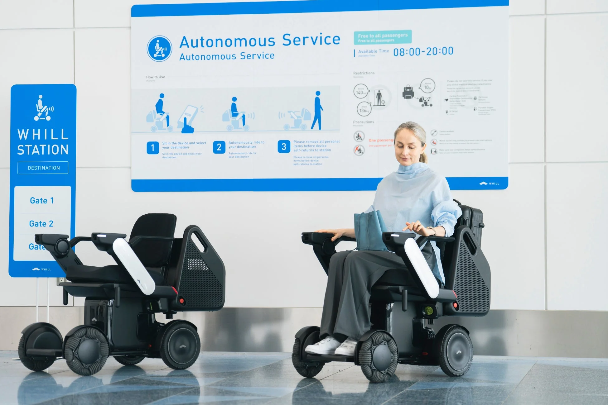 空港のターミナルで、WHILLの自動運転サービスを利用する女性と、そのサービス案内板