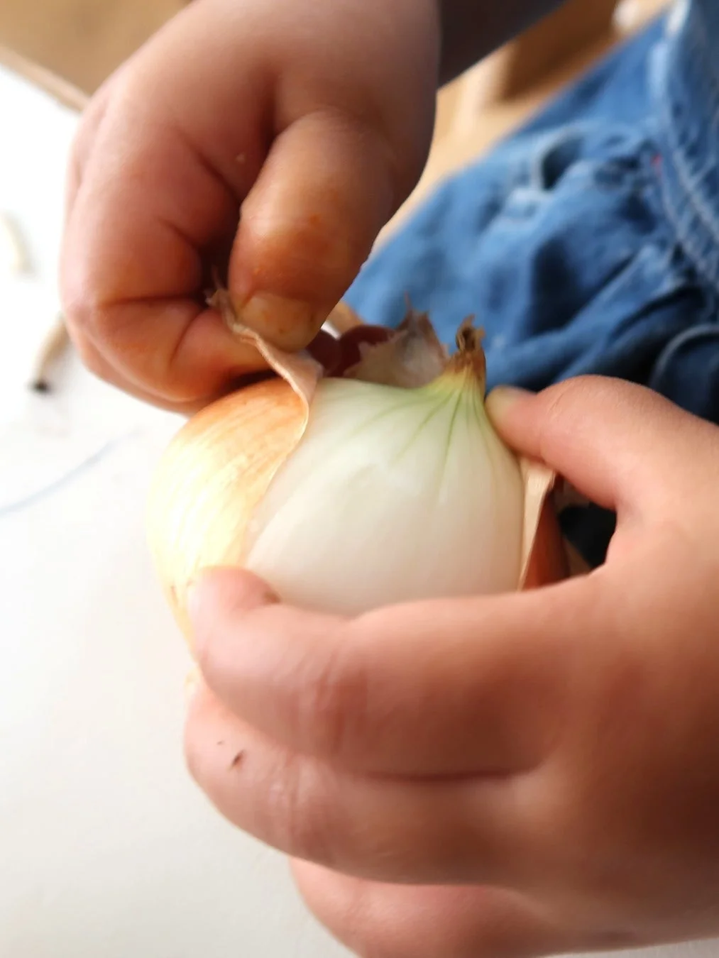 玉ねぎの皮むきをする子供の手
