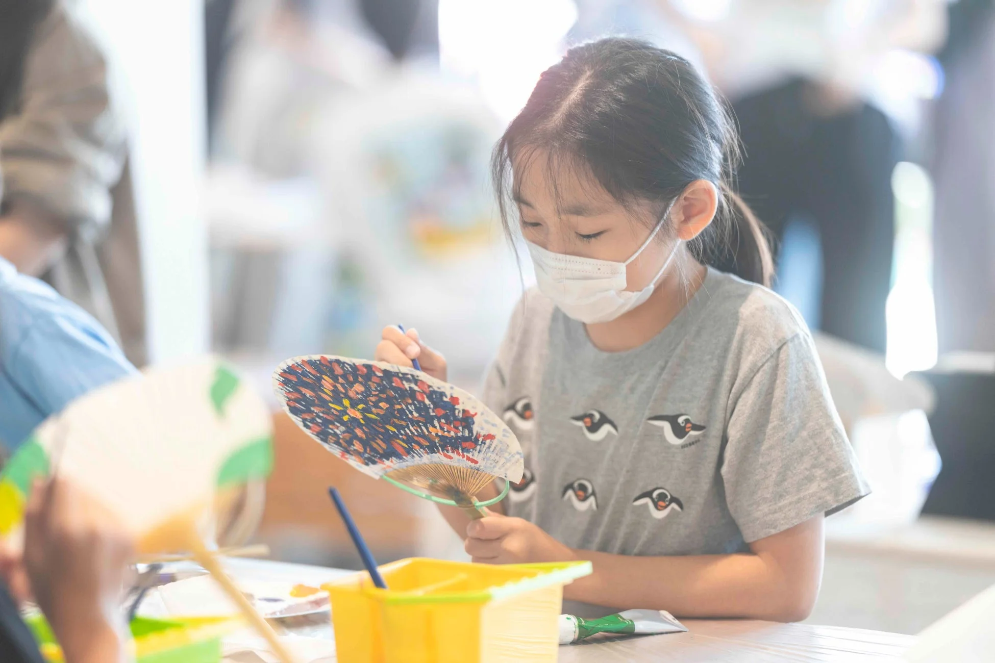 扇子に絵付けをする女の子