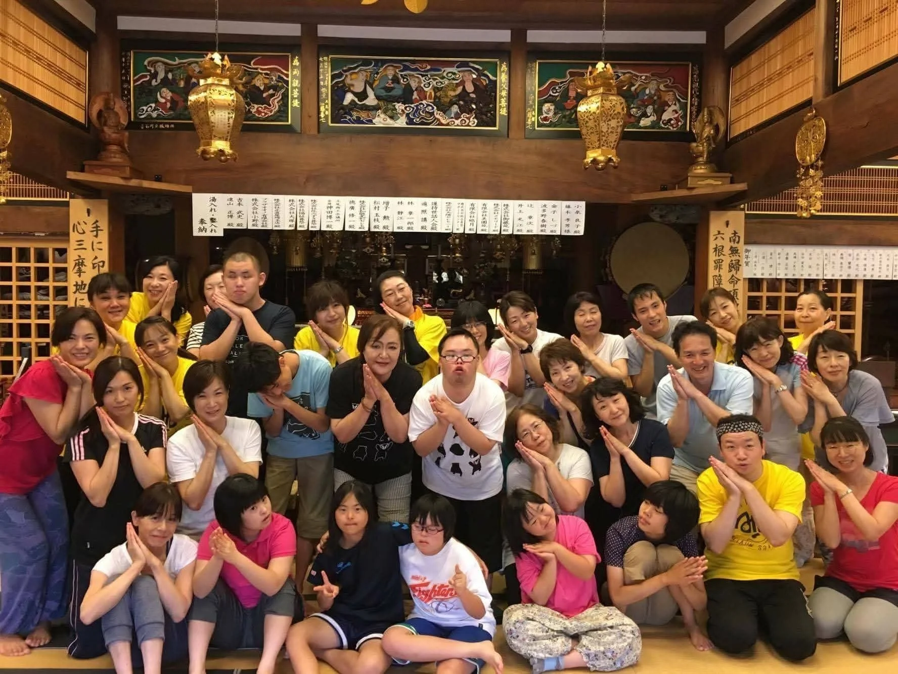 日本の伝統的な建物で集合写真に収まる人々