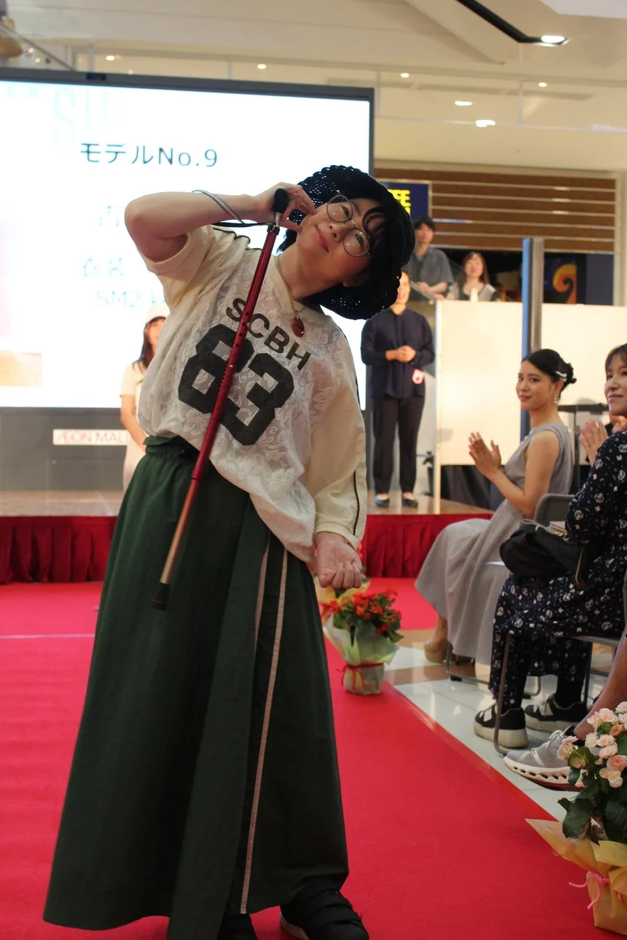 杖と帽子をかぶった女性モデル
