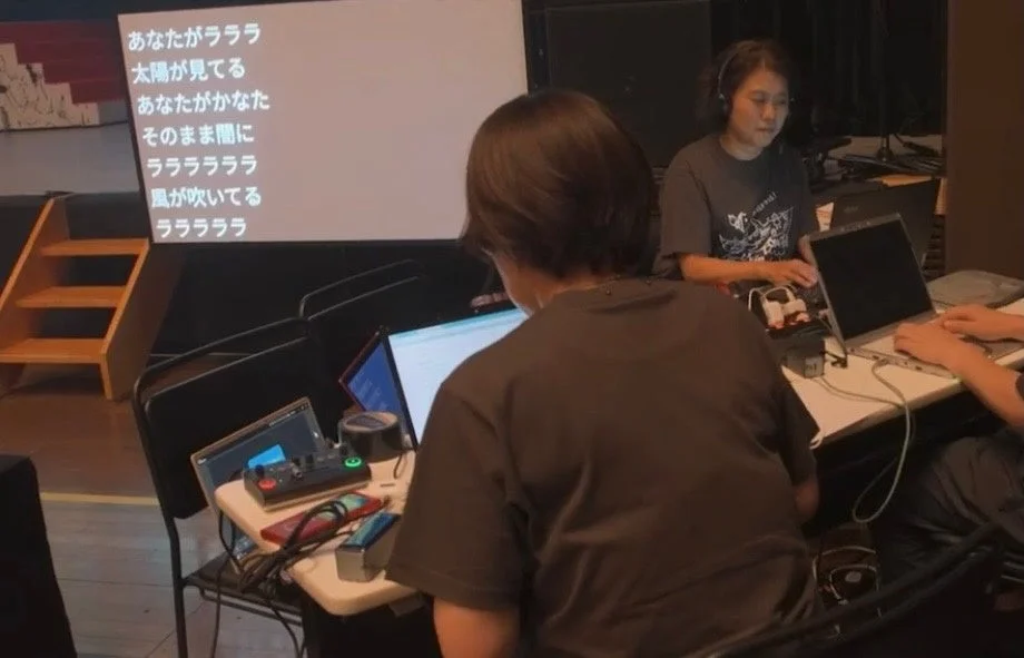 プロジェクターに歌詞が映し出された会場