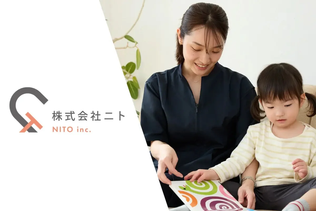 笑顔の女性が子供と一緒に絵本を読む様子