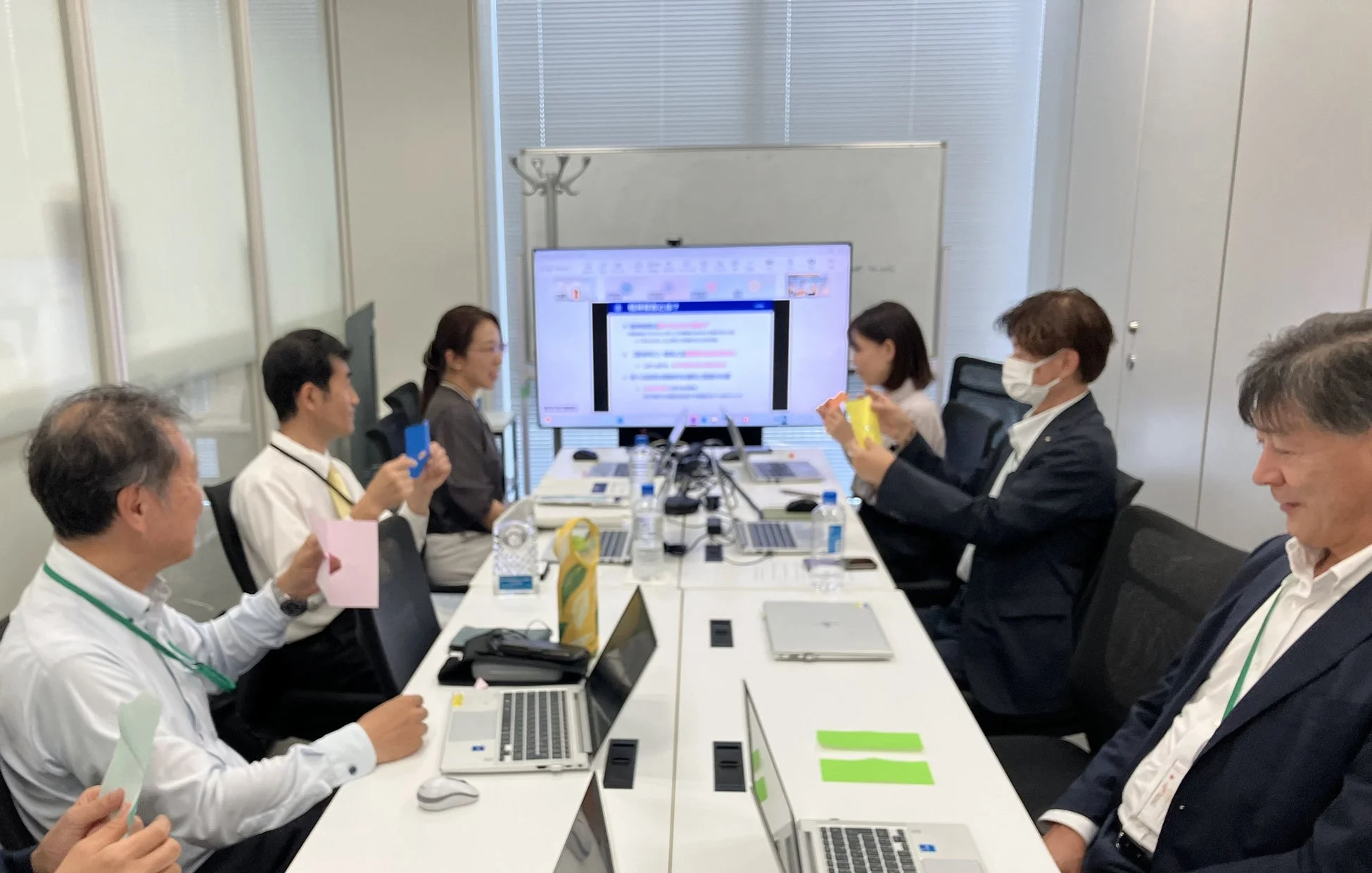 会議で色付きカードを持つ参加者たち
